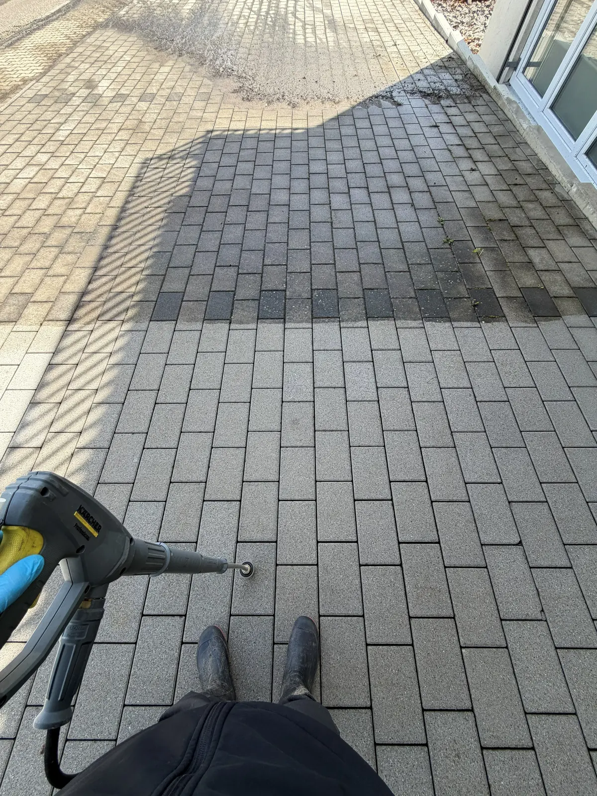Pflasterfläche wird mit dem Hochdruckreiniger gereinigt